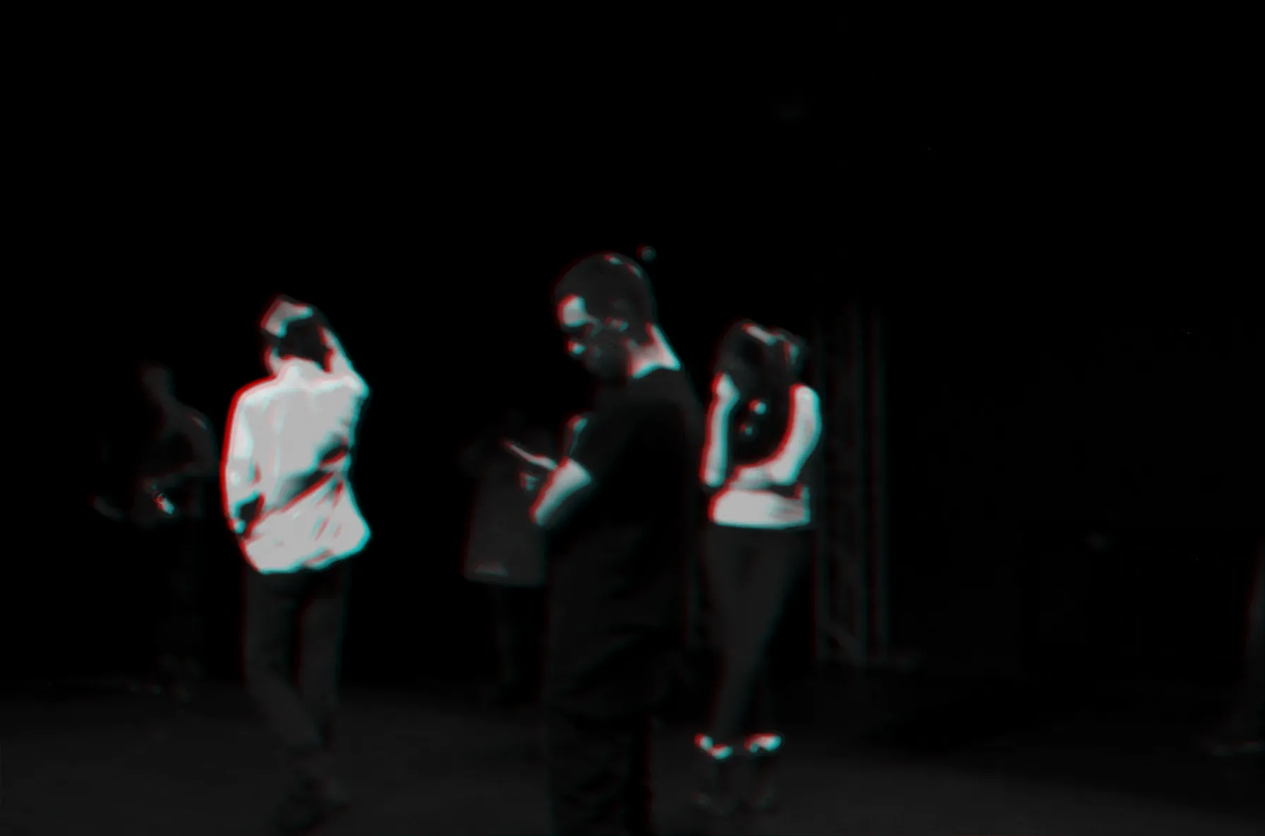 Participants standing on a stage in blue light