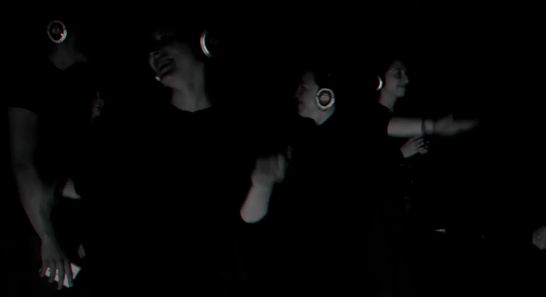 Participants in headphones moving in the dark